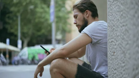 Young Man Checking Smartphone Outdoors Stock Footage 129344823