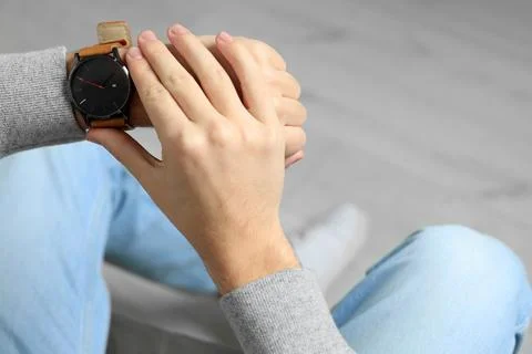 Young man checking time in room, closeup and space for text. Being late Stock Photos