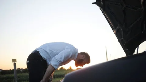 Young man checking under the bonnet of his car in slow motion nervous automobile Stock Footage 92067030