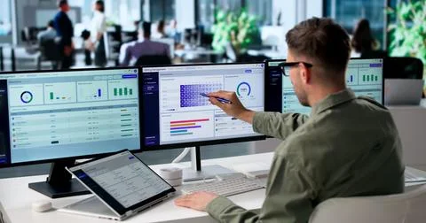 Young Man Checks Subscription Billing And Analytics On Laptop And Tablet. Stock Photos