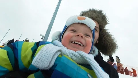 A young man with a cheerful boy with a roller coaster ride in the winter on the 動画素材 101441751