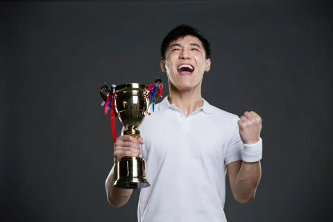 Young man cheering with a trophy Stock Photos