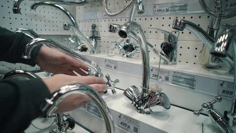 Young man chooses and buys mixer tap in supermarket. Stock Footage 108740475