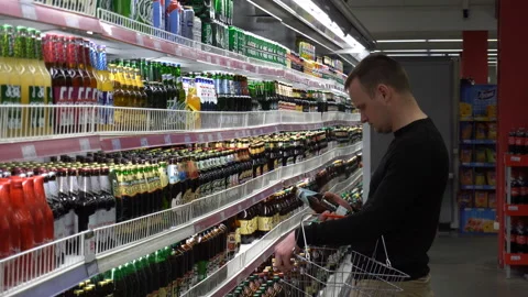 The young man chooses a beer for bbq party with friends in the supermarket. Stock Footage 89592970