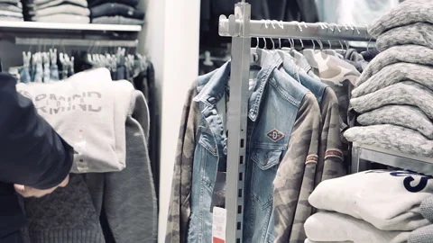 Young man choosing clothes in mall or clothing store. Sale, shopping, fashion. Stock Footage 85688435