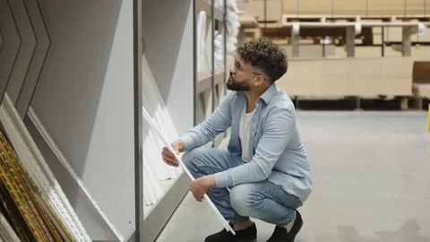 Young man choosing crown molding in hardware store Stock-Footage 336965075