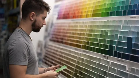 Young man choosing paint chips or swatches in a hardware store. Home remodeling Stock Footage 280187290