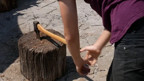 Young man choping firewood with axe on stamp in backyard Stock Footage 113742676
