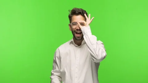 Young man on chroma confident doing ok gesture on eye Stock Footage 97589167