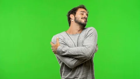 Young man on chroma green screen giving a hug Stock Footage 97706157