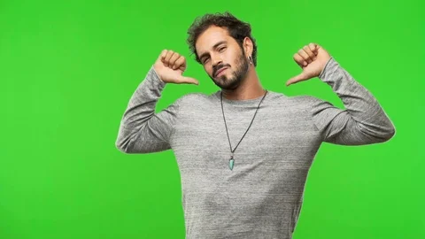 Young man on chroma green screen pointing fingers, example to follow Stock Footage 97706161