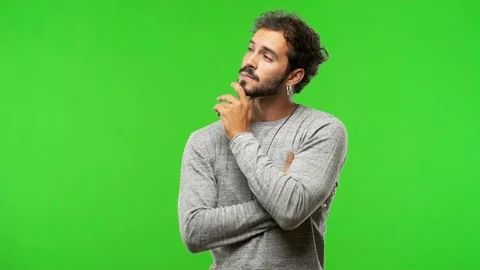 Young man on chroma green screen thinking about an idea Stock Footage 97706189