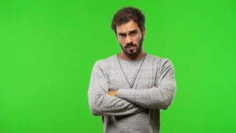 Young man on chroma green screen with arms crossed Stock Footage 97706196