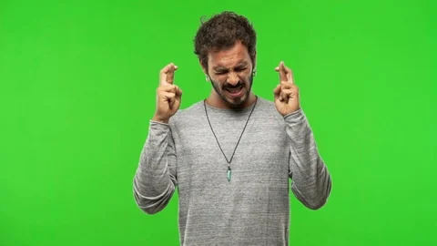 Young man on chroma green screen crossing fingers Stock Footage 97706262