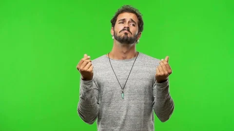 Young man on chroma green screen making a gesture of need Stock Footage 97706267