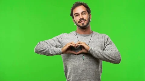 Young man on chroma green screen making a heart with hands Stock-Footage 97706480