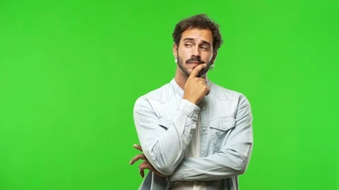 Young man on chroma green screen doubting and confused Stock Footage 97707408