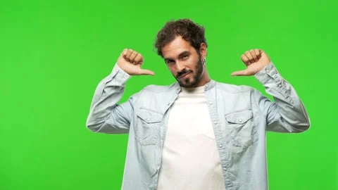 Young man on chroma green screen pointing fingers, example to follow Stock Footage 97707431