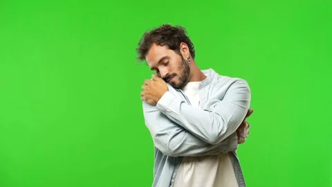 Young man on chroma green screen giving a hug Stock Footage 97707434