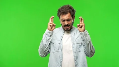 Young man on chroma green screen crossing fingers Stock Footage 97707655