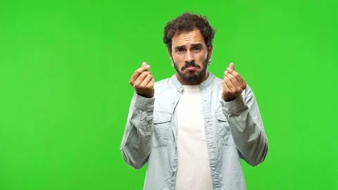Young man on chroma green screen making a gesture of need Stock Footage 97707668