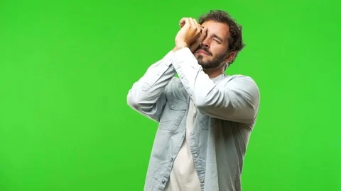 Young man on chroma green screen making the gesture of a spyglass Stock Footage 97707831