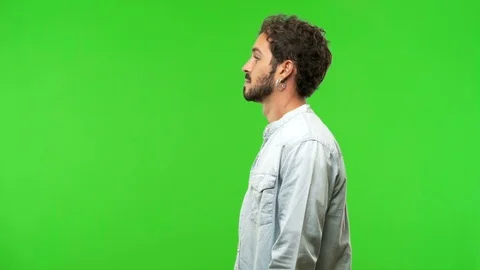Young man on chroma green screen on the side looking Stock-Footage 97708091