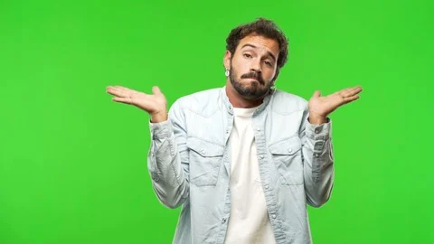 Young man on chroma green screen confused and doubtful Stock Footage 97708157
