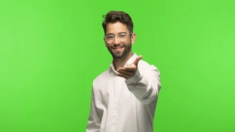 Young man on chroma reaching out to greet someone Stock-Footage 97589274