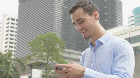 Young man in city checking his smartphone Stock Footage 85868097