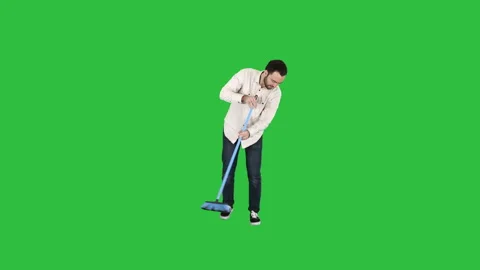 Young man cleaning floor with brush on a Green Screen, Chroma Key. Stock-Footage 101762366