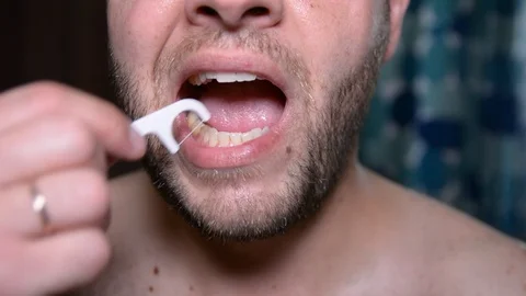 Young man cleaning teeth with dental floss. dental hygiene, people and beauty co Видео 92183545