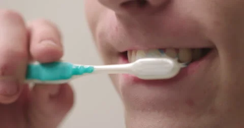Young man cleans his teeth in slow motion extreme close up 4K Stock Footage 66525155
