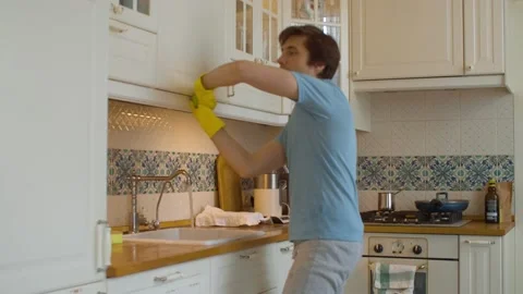 Young man cleans up kitchen Video stock 131067778