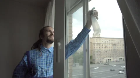 A young man cleans the window Stock Footage 65287903