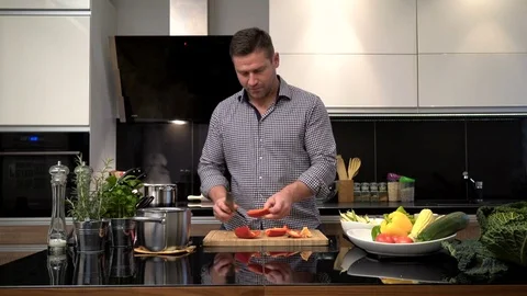 Young man cleansing and cutting pepper. Vídeo Stock 70589049