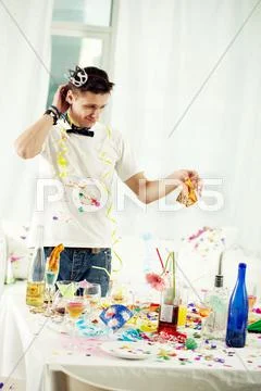 Young man clearing table after birthday party Stock Photos