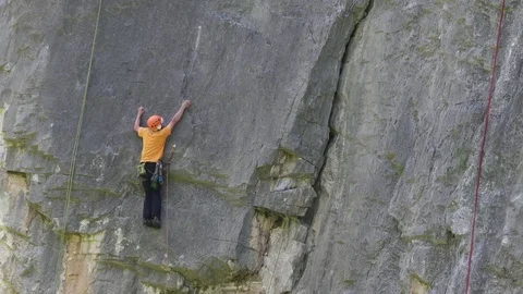Young man climbing on cornice on wall Stock-Footage 69800685