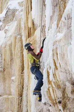 Young man climbing the ice using ice axe Stock-Fotos