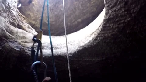 Young man climbing on a rock in a Cave. Climbing equipment. Stock Footage 139467180