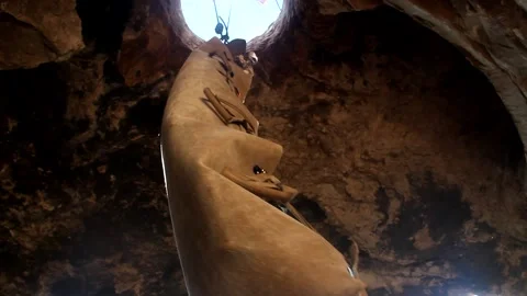 Young man climbing on a rock in a Cave. Climbing equipment. Stock Footage 139467218