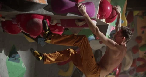 Young man climbing wall with help of holds Stock Footage 259985356