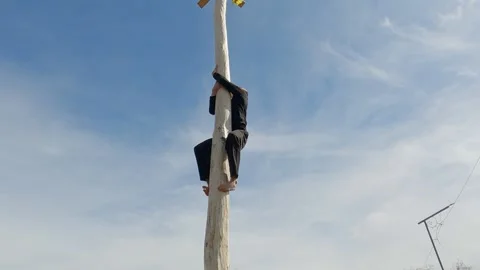 A young man climbs a pole for fun during the holiday Maslenitsa. Stock Footage 271199855