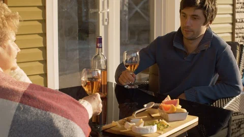 Young man clinks wine glasses with senior woman Stock Footage 129256586