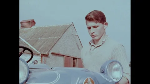 Young man closes tractor bonnet and installs exhaust, UK 1961 Stock Footage 133385537
