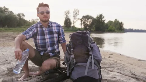 Young Man Closing the Bottle With the Cap in the Wild Stock Footage 76453894