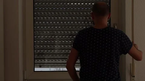 Young man closing the window shutter during the day Stock-Footage 242720028