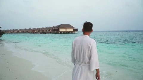 A young man on the coast in a robe Stock Footage 146652096