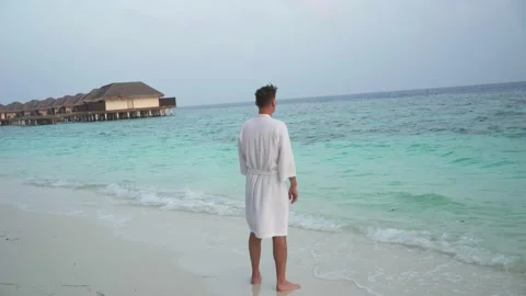 A young man on the coast in a robe Stock Footage 146652111