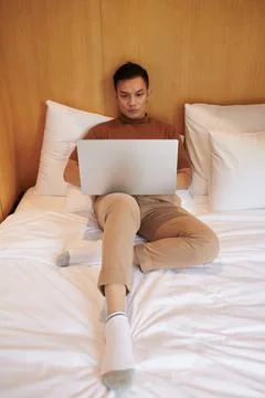 Young Man Coding in Bed Stock Photos